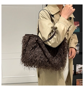 Gros plan détaillé d'un sac cabas marron foncé à franges avec texture pelucheuse et lanière