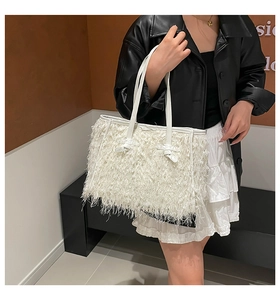 Détail d'un sac cabas en peluche blanche avec des franges douces et anses en cuir fin