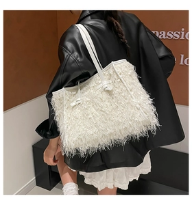 Détail du sac cabas blanc à franges montrant une texture de plumes sur l'épaule