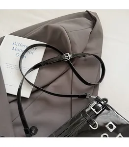Detail of adjustable leather strap and silver metal buckle on a black punk style bag