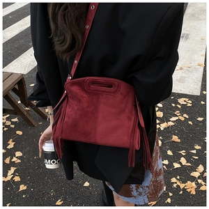 Detail der burgunderroten Wildledertasche mit langen Fransen und hohlem Griffdesign