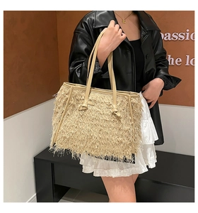 Gros plan détaillé sur un sac fourre-tout en paille beige avec textures de franges
