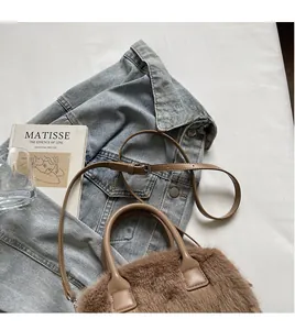 Detail of soft brown faux fur handbag with leather strap and silver metal hardware