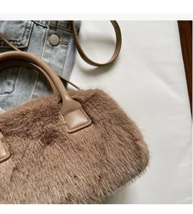 Detail of plush faux fur texture and smooth leather strap on a brown shoulder bag