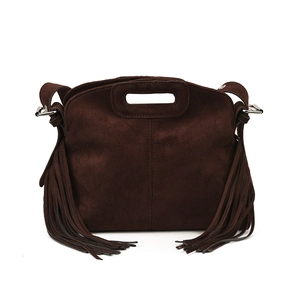Detail einer dunkelbraunen Wildleder-Schultertasche mit Fransen und Schnalle