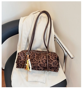 Detail of leopard print cylinder handbag with colorful beaded tassel on velvet fabric