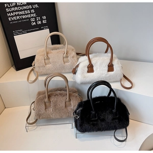 Detailed display of fuzzy Boston bags in cream, white, khaki, and black on a white shelf
