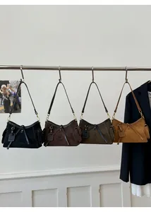 Detailed close-up of retro suede crossbody bags in four colors with stitching details