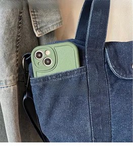 Close-up of deep blue denim tote bag pocket holding a green smartphone case