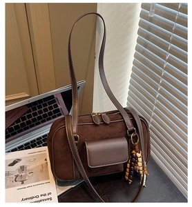 Detail of vintage brown suede shoulder bag with ethnic beaded tassel and side pocket