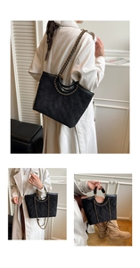 Detail of black quilted tote bag with retro chain strap and unique cutout handle