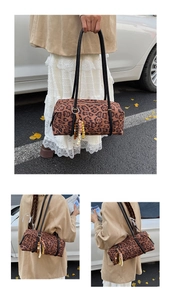 Close-up of leopard print cylinder bag featuring long black handles and colorful tassel