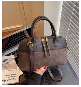 Detail of rhombic quilted stitching and bicolor brown leather texture on the shell handbag