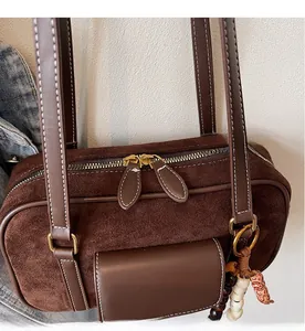 Detail of vintage brown Boston bag with smooth dual zippers and beaded tassel charm