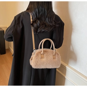 Fuzzy faux fur crossbody bag in light brown worn over a black winter coat