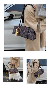 Detail of leopard print cylinder shoulder bag with beaded fringe and black double straps