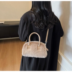 Detail showing the plush beige faux fur shoulder bag worn by a model in a stylish interior