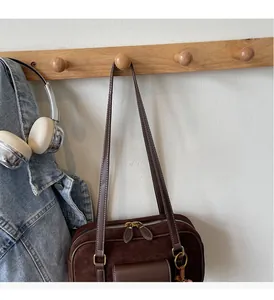 Close-up of retro dark brown suede Boston bag with metal ring and double zippers