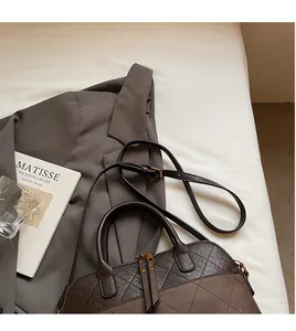 Detailed top view of a dark brown quilted shell bag with elegant mixed leather texture