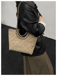 Détail du sac cabas matelassé beige avec bandoulière en chaîne dorée et texture en daim
