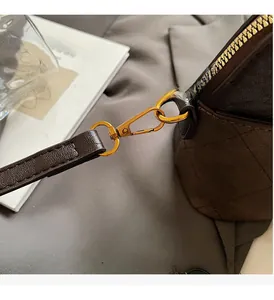 Macro detail of golden metal hardware and quilted leather strap on shell bag