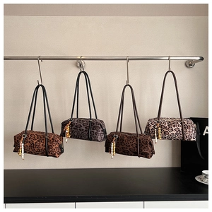 Detail view of four leopard print barrel shoulder bags with colorful beaded charms