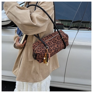 Detail of leopard print cylindrical bag with colorful wooden beads and black strap