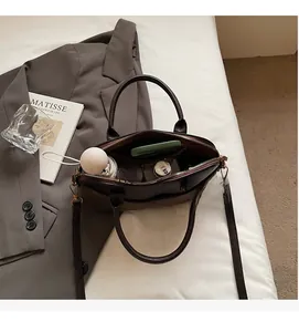 Top view of open quilted shell bag showing large capacity with wallet and water bottle