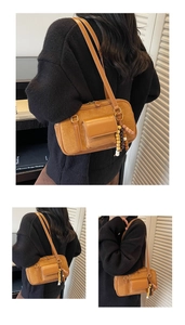Detail of caramel suede Boston bag with leather flap pocket and colorful beaded charm