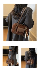 Close-up of retro dark brown frosted suede Boston bag with bohemian beaded charms
