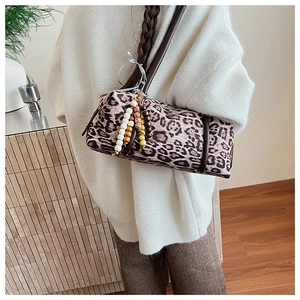 Detail of leopard print cylinder shoulder bag with colorful beaded tassel charm
