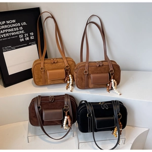 Detail of four matte retro hobo bags in assorted colors with wooden bead zipper pulls