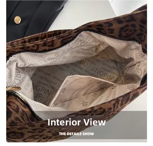 Interno della borsa leopardata che mostra la fodera spaziosa e le tasche con zip