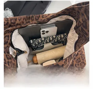 Interno spazioso di una borsa shopper leopardata con tablet, portafoglio e accessori