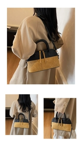 Detail of a retro quilted shell bag featuring contrast stitching and dual zipper closure