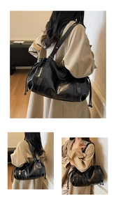 Detail of black soft leather shoulder bag featuring drawstring side and silver metal eyelets