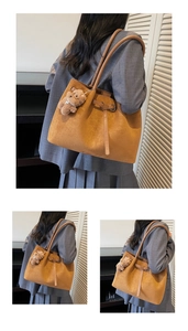 Detail of a brown suede tote bag with shoulder straps and a cute teddy bear charm