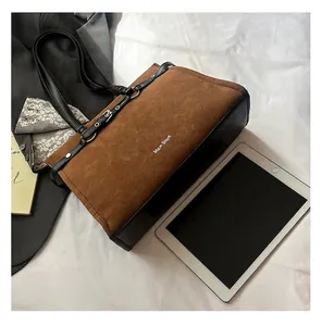Overhead view of large brown suede tote bag with laptop and office essentials