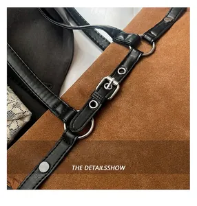 Detail view of brown suede shoulder bag showing silver ring hardware and adjustable strap