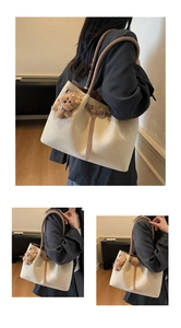 Detail of canvas tote with brown leather straps and cute plush bear charm hanging