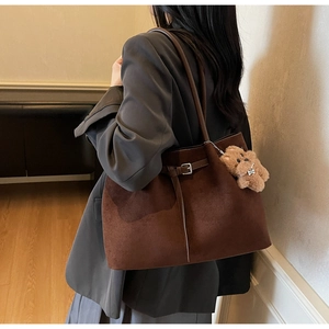 Detail der braunen Vintage-Tote-Bag mit Wildleder-Textur und süßem Plüschbär-Anhänger