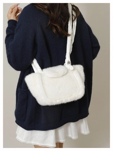 Detailed back view of a plush white faux fur shoulder bag with a quilted wide strap