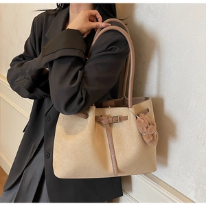 Detailed macro view of retro tote bag texture with brown straps and plush bear charm