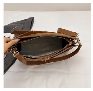 Detail view of brown leather bag interior with zipper compartment and gray fabric lining