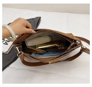 Interior view showing the large capacity and compartments of the brown leather shoulder bag