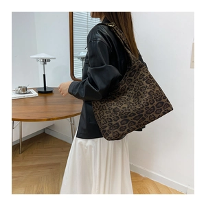 Dettaglio della borsa hobo scamosciata con stampa leopardata indossata da una modella
