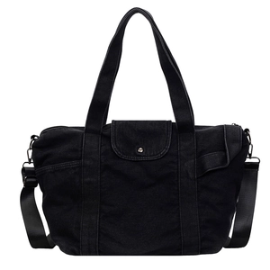 Minimalist black denim tote bag with dual straps and silver snap pocket for daily commuting