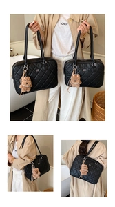 Detail of black quilted tote bag with COIN '20N logo and cute brown bear pendant