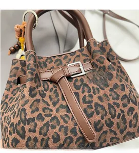 Detail of leopard print handbag with soft fabric texture and decorative beaded tassels