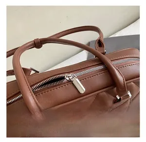Detailed macro view of brown quilted leather bag with premium silver metal zipper